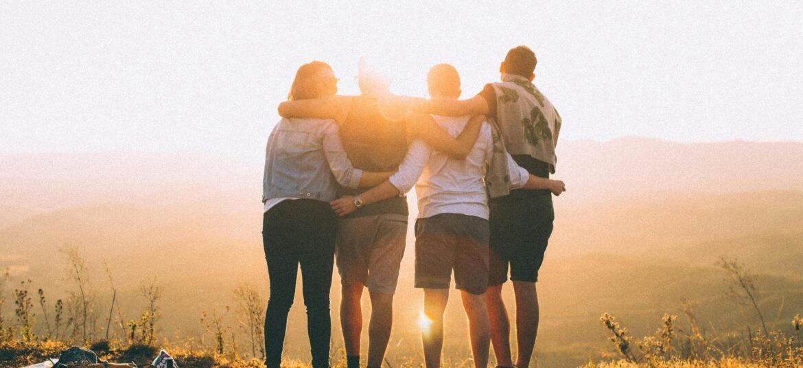 A group of friends embrace while enjoying a breathtaking sunrise over the Brazilian highlands.