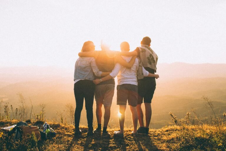 A group of friends embrace while enjoying a breathtaking sunrise over the Brazilian highlands.
