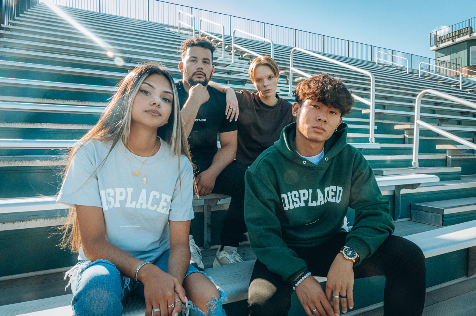 A fashionable group of young adults seated on outdoor bleachers, showcasing modern style.